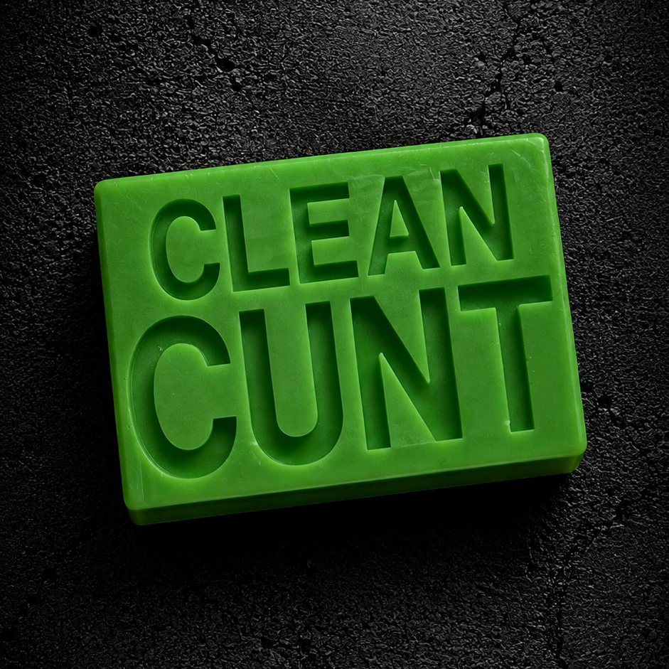 A bright green rectangular bar of soap with the words 'CLEAN CUNT' embossed on the front, set against a dark textured background.